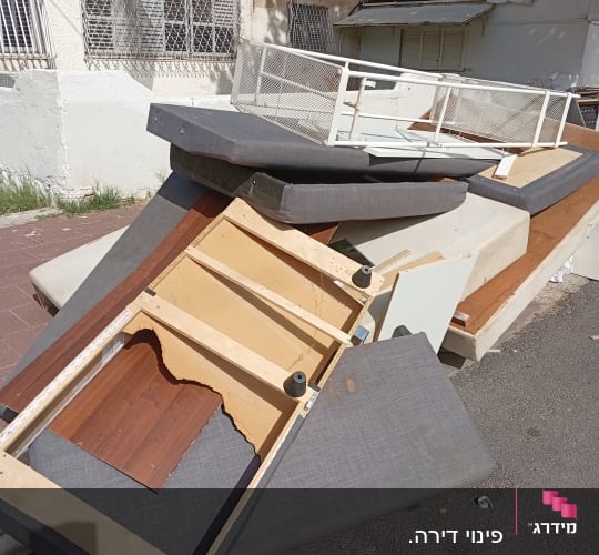 רהיטים ישנים ופסולת ברחוב ליד בניין מגורים